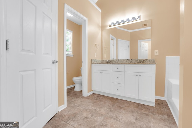 bathroom featuring baseboards, visible vents, toilet, and double vanity