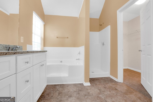 bathroom with a garden tub, vanity, baseboards, and walk in shower