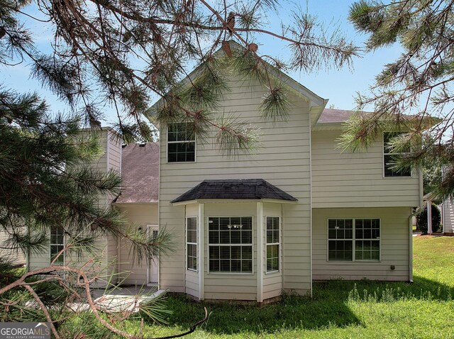 rear view of house featuring a lawn