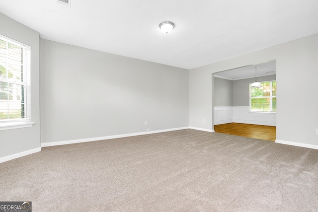 carpeted spare room with visible vents and baseboards