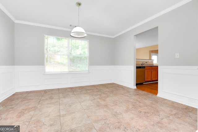 empty room featuring wainscoting and crown molding