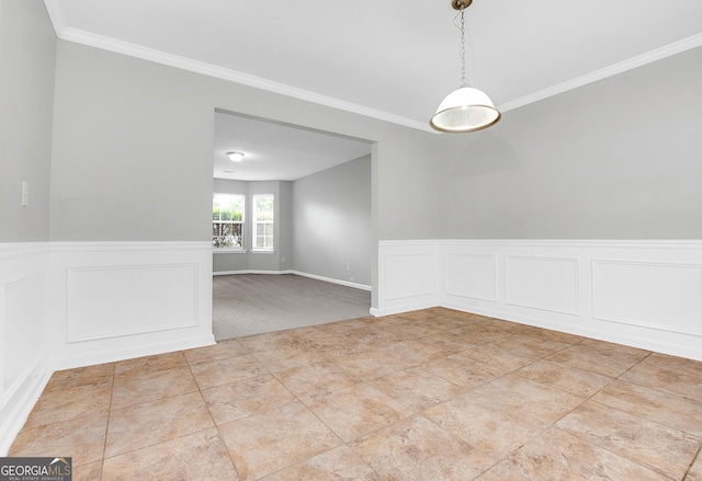 unfurnished room with light tile patterned floors, ornamental molding, and wainscoting