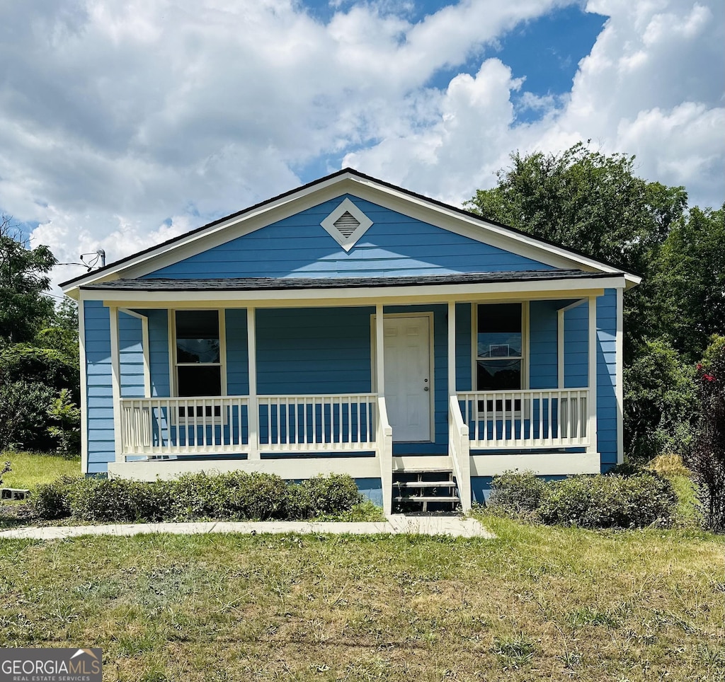 bungalow-style house with covered porch and a front lawn