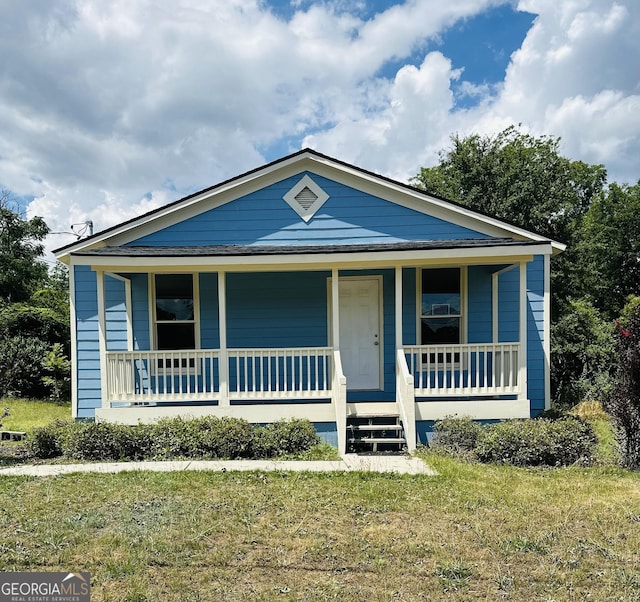 bungalow-style house with covered porch and a front lawn