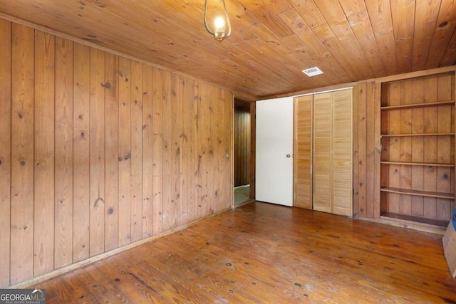 unfurnished bedroom with hardwood / wood-style flooring, wood walls, and wooden ceiling