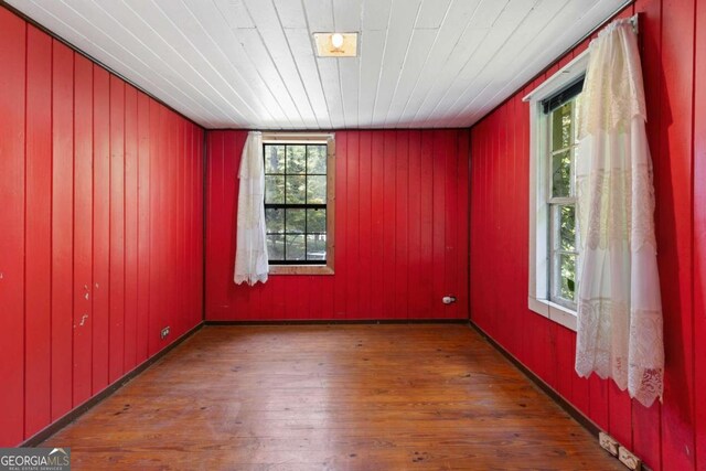 empty room featuring a healthy amount of sunlight and hardwood / wood-style flooring