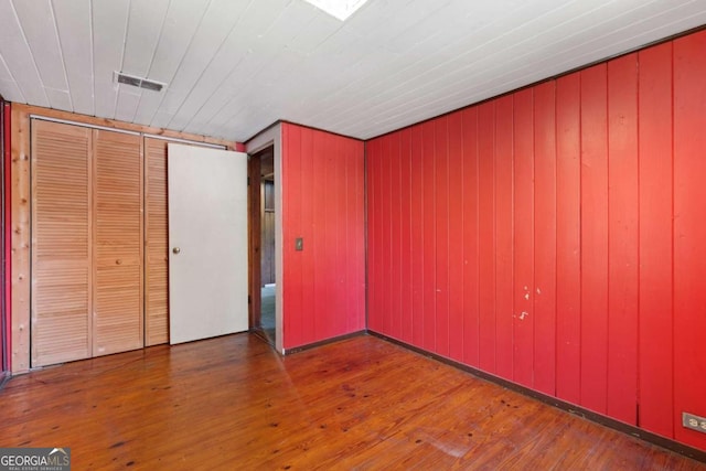 unfurnished bedroom featuring a closet and hardwood / wood-style flooring