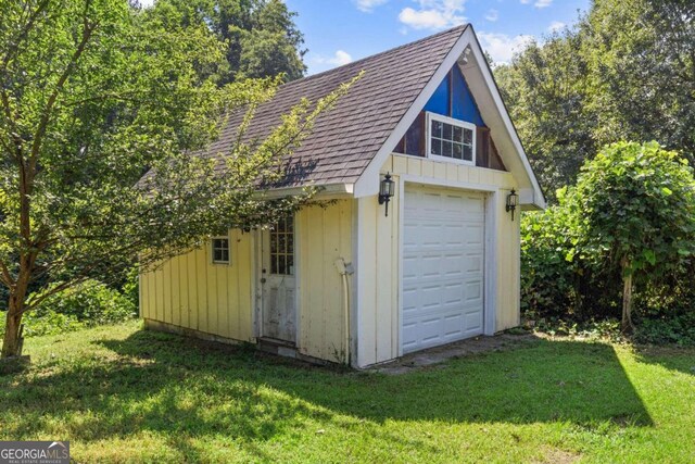 view of outdoor structure with a garage and a yard