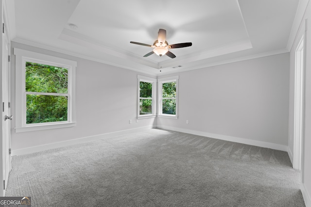 carpeted empty room with a tray ceiling, ceiling fan, and crown molding