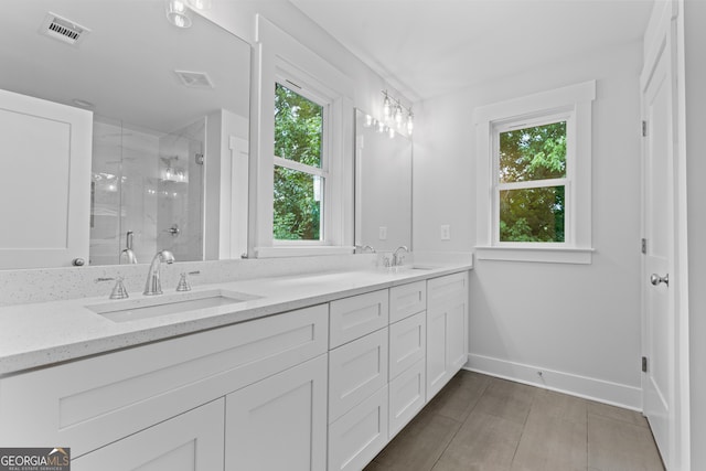 bathroom featuring tile patterned floors, a shower with door, and vanity