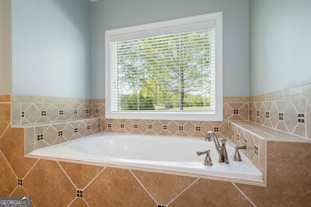 bathroom with tiled tub and a healthy amount of sunlight