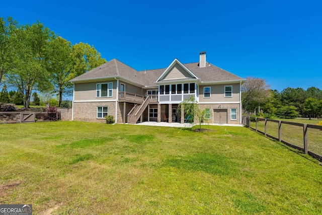 rear view of property with a wooden deck and a lawn