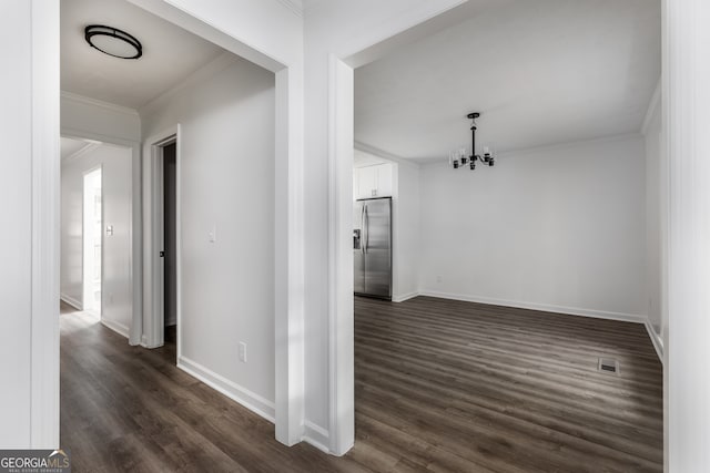 interior space with crown molding, dark wood-type flooring, and an inviting chandelier