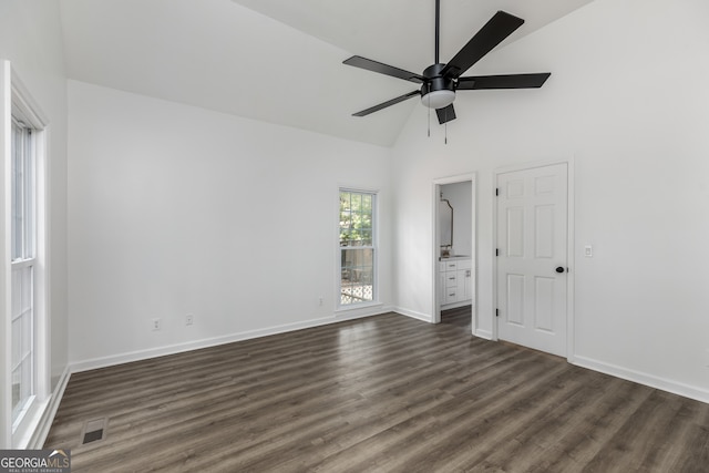 spare room featuring dark wood-type flooring, ceiling fan, and high vaulted ceiling