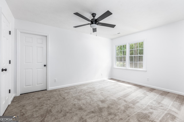 carpeted empty room featuring ceiling fan