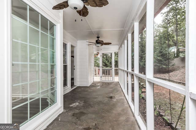 unfurnished sunroom with ceiling fan