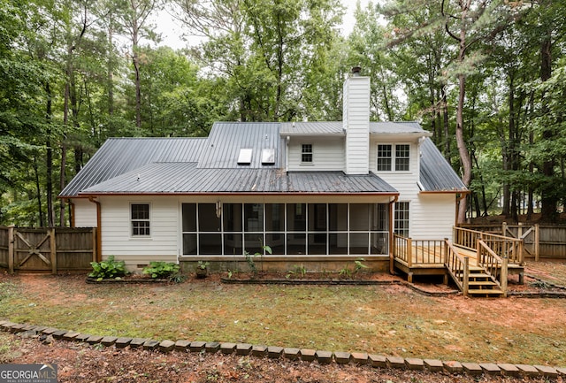 back of house with a sunroom and a deck