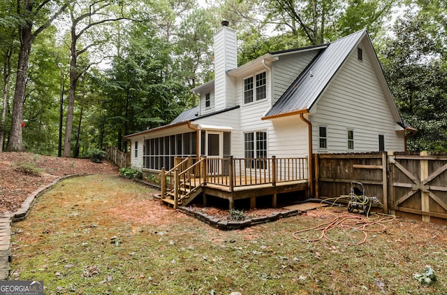 back of property with a sunroom and a deck