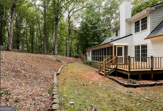 view of yard with a wooden deck and a sunroom