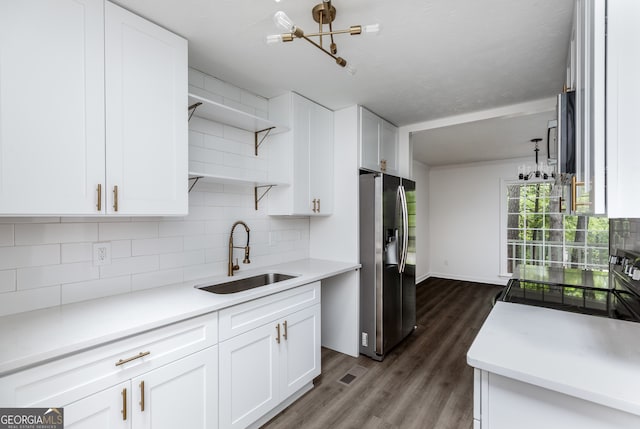 kitchen with white cabinets, appliances with stainless steel finishes, sink, dark wood-type flooring, and decorative backsplash