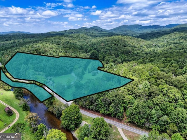 aerial view featuring a wooded view and a mountain view