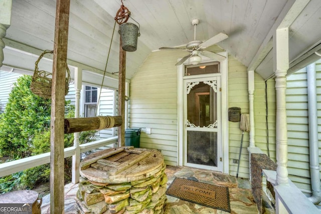 exterior space featuring ceiling fan, vaulted ceiling, wood ceiling, and a healthy amount of sunlight