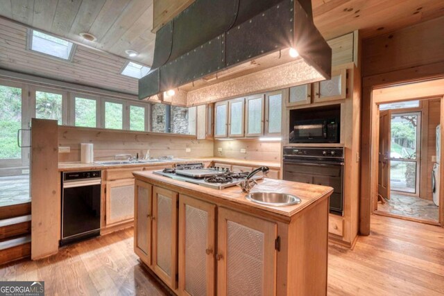 kitchen with a wealth of natural light, black appliances, light hardwood / wood-style floors, and wooden ceiling