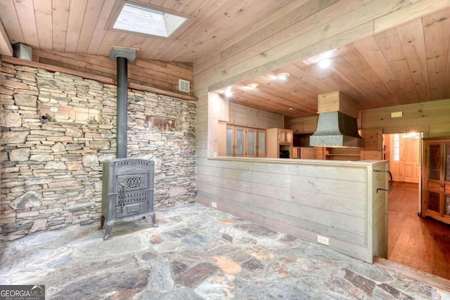 interior space featuring a skylight and a wood stove