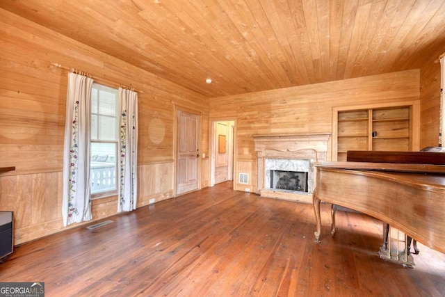 unfurnished living room with hardwood / wood-style flooring, a fireplace, wood walls, and wood ceiling