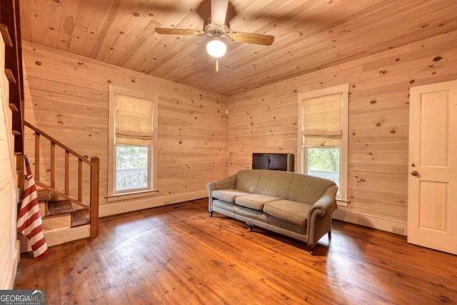 living room with wood ceiling, ceiling fan, hardwood / wood-style floors, and wood walls