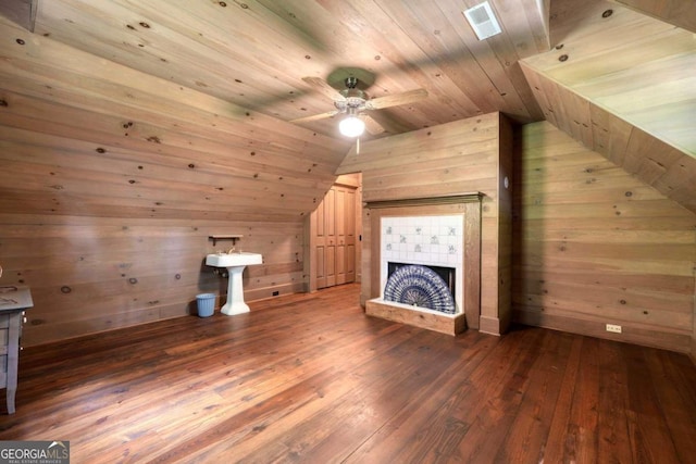 additional living space featuring lofted ceiling, wooden ceiling, wooden walls, visible vents, and hardwood / wood-style floors