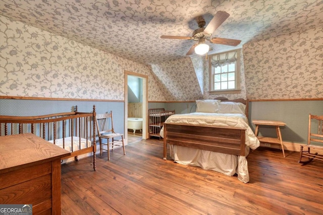 bedroom with ceiling fan, hardwood / wood-style floors, and vaulted ceiling