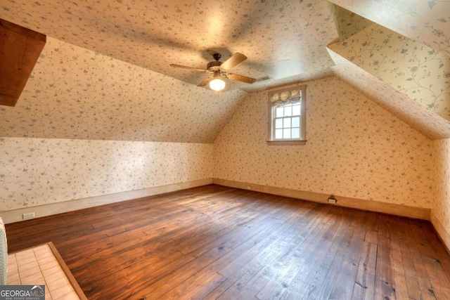 bonus room featuring vaulted ceiling, ceiling fan, wood-type flooring, and wallpapered walls