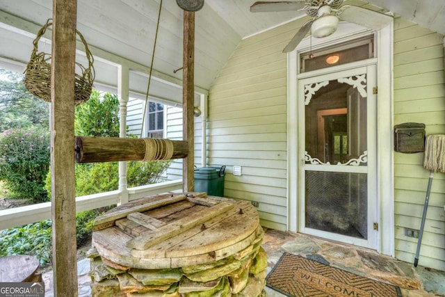 view of exterior entry with a ceiling fan and covered porch