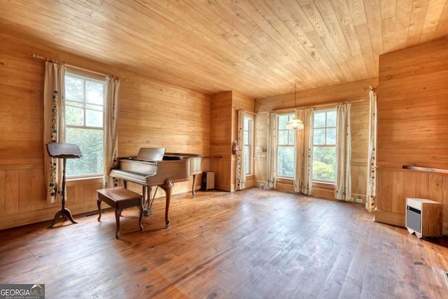 sitting room featuring wooden ceiling, wood-type flooring, and wooden walls