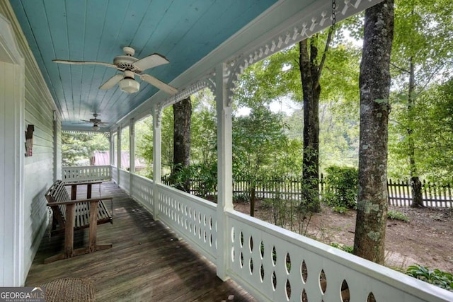 wooden deck with covered porch, fence, and a ceiling fan