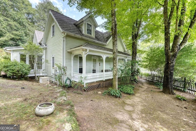 view of front of property featuring a porch and fence