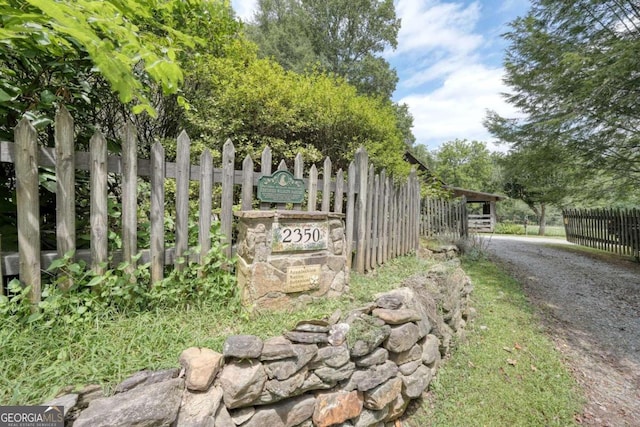 community / neighborhood sign with fence and driveway