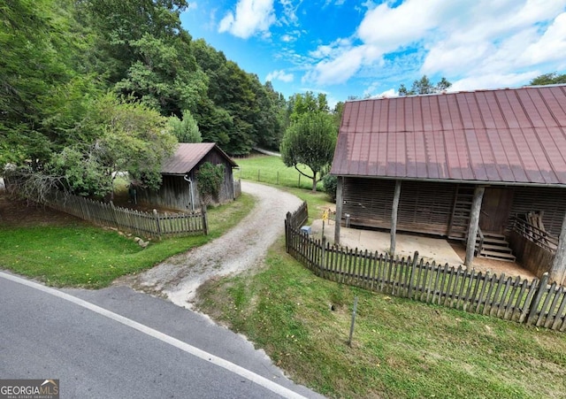 view of home's exterior with metal roof and driveway