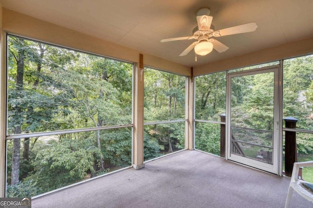 unfurnished sunroom featuring ceiling fan