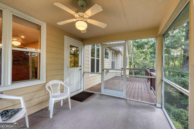 unfurnished sunroom with ceiling fan