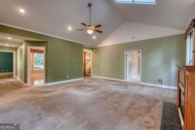 interior space featuring carpet flooring, ceiling fan, high vaulted ceiling, and a skylight