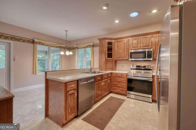 kitchen featuring sink, stainless steel appliances, light tile patterned floors, and kitchen peninsula