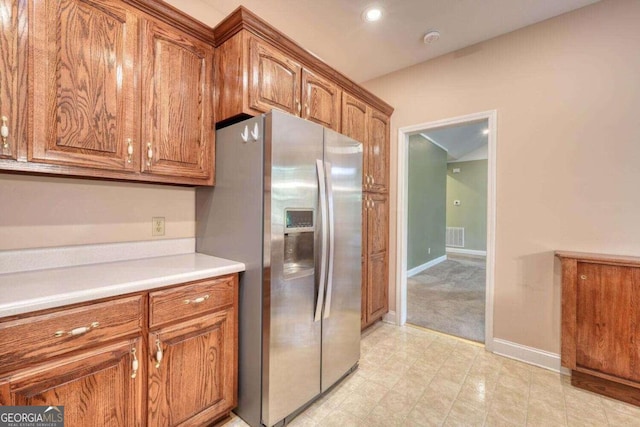 kitchen with light tile patterned floors and stainless steel refrigerator with ice dispenser