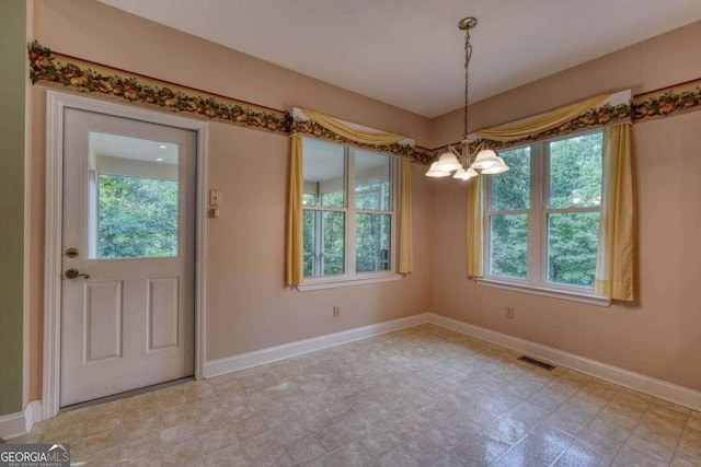 tiled foyer entrance featuring a notable chandelier