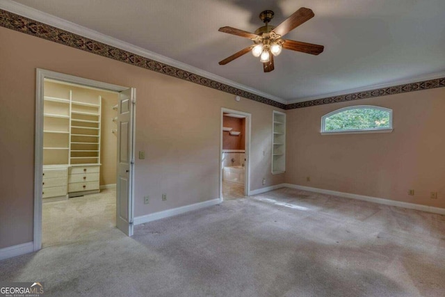 carpeted spare room featuring ceiling fan and crown molding