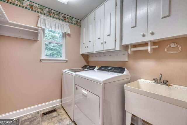 laundry room with sink, washer and dryer, cabinets, and light tile patterned floors