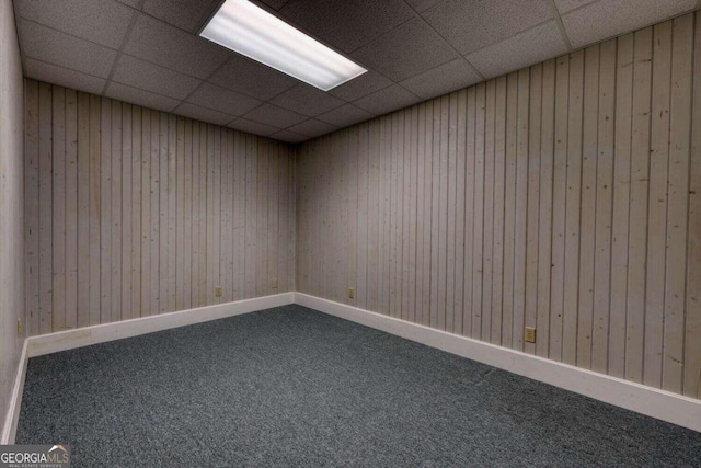 carpeted empty room with a drop ceiling