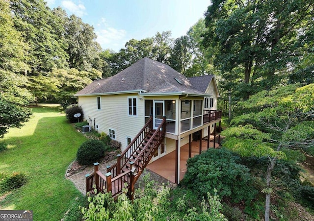 rear view of house featuring central AC unit, a wooden deck, and a yard