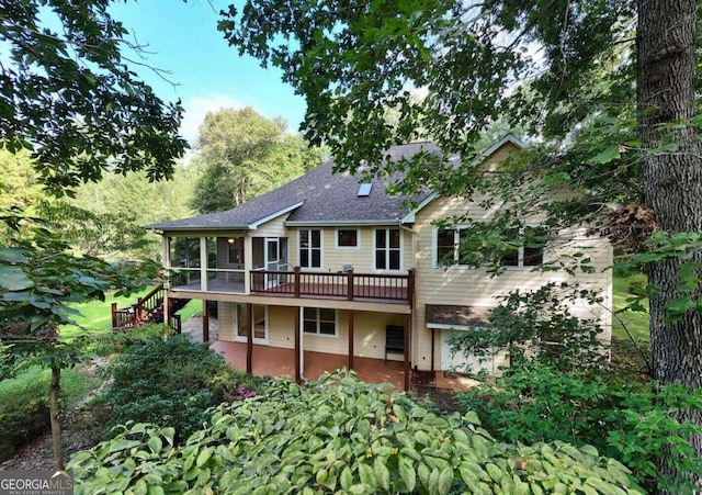 rear view of house featuring a wooden deck